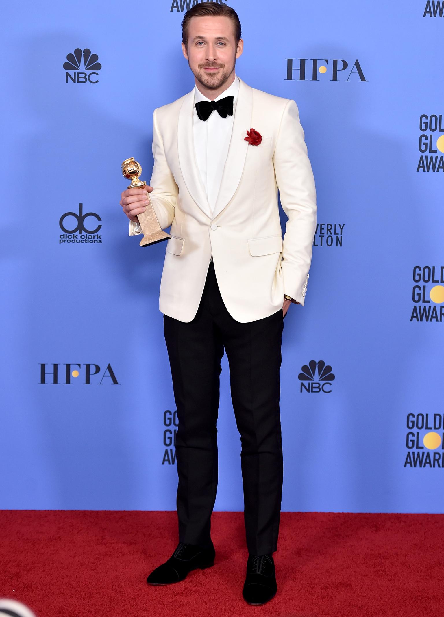 Actor Ryan Gosling poses in a white tuxedo at the Golden Globe Awards 2017