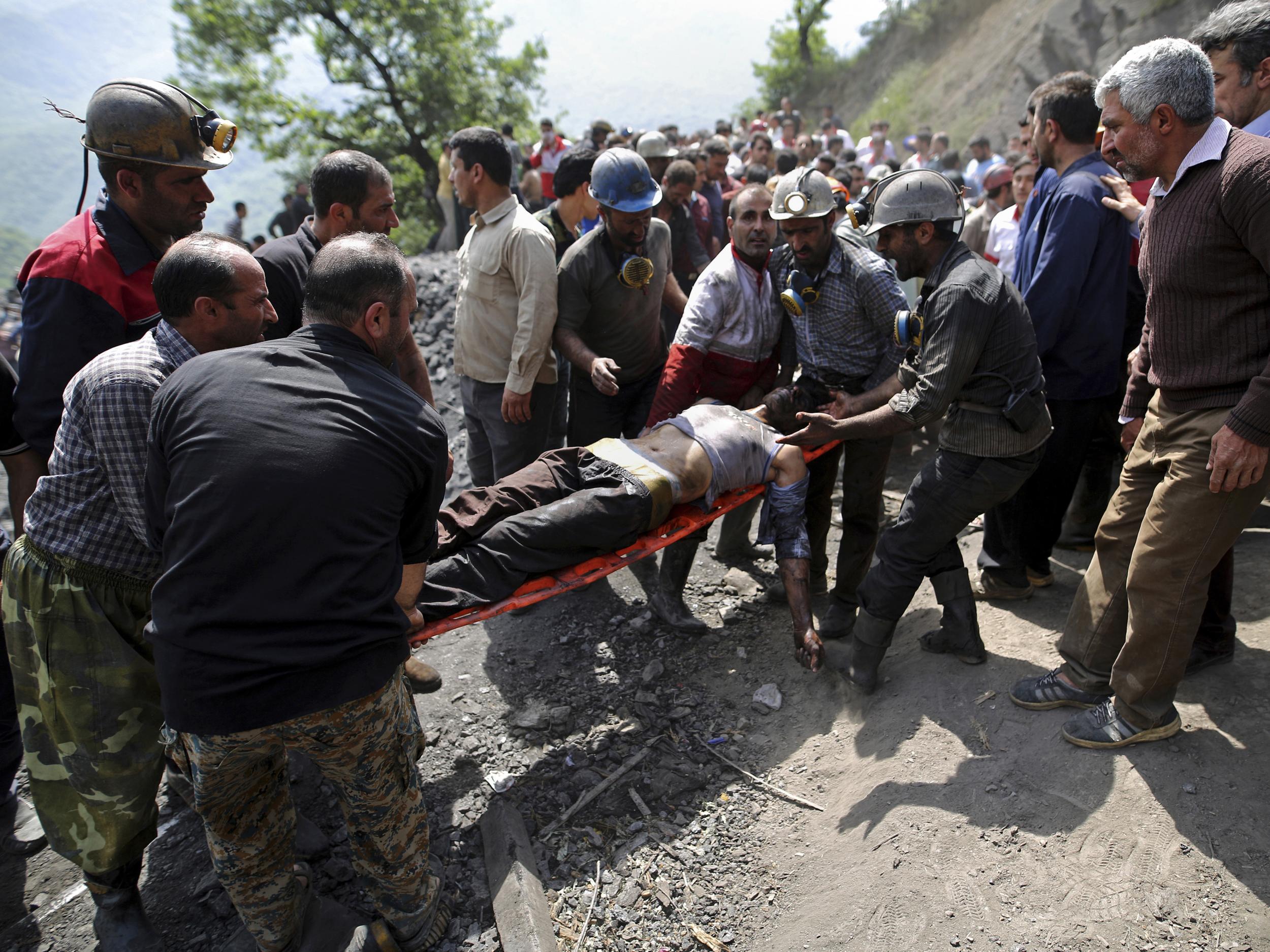 File. Miners and rescue personnel carry an injured mine worker after a coal mine explosion near Azadshahr, Iran, in 2020