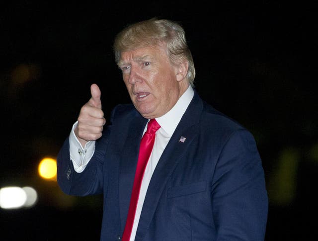 President Donald Trump gestures to the press as he walks on the South Lawn of the White House in Washington, DC