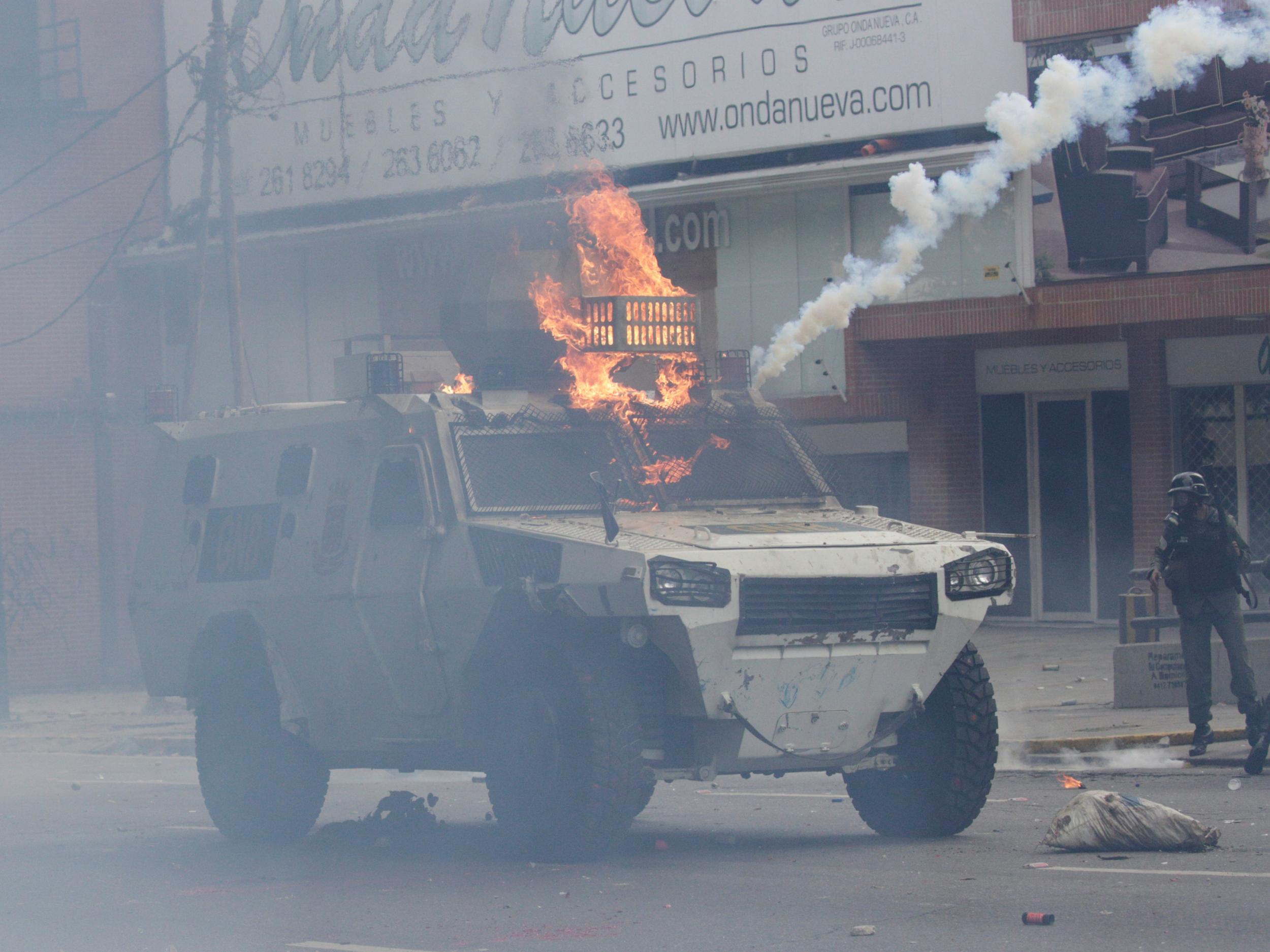 An armoured police vehicle is hit by petrol bombs thrown by opposition supporters while clashing with riot police during a rally