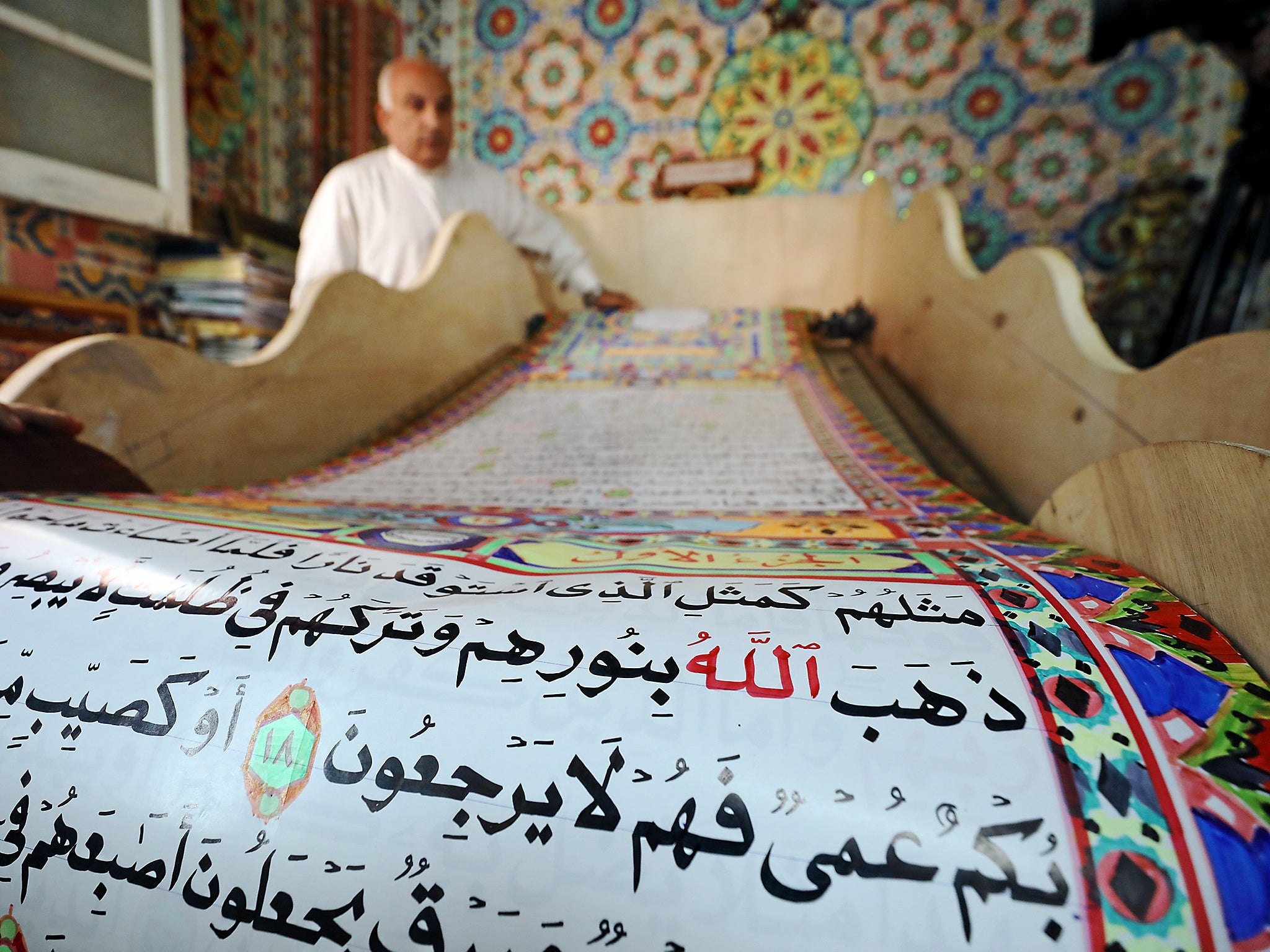 &#13;
Saad Mohammed rolls down the handwritten Quran he hopes will earn a place in the Guinness Book of Records &#13;