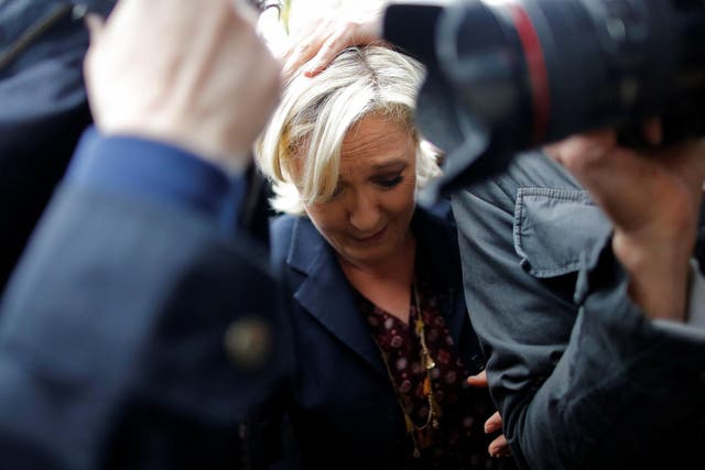 Marine Le Pen is protected by security as protesters throw eggs in Dol-de-Bretagne