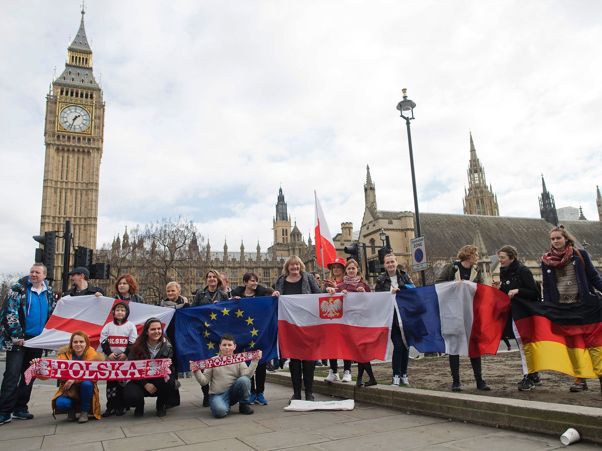 Protesters pose for a photograph with flags from England, European Union, Poland, France and Germany in front of Parliament