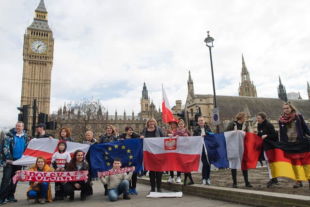 Protesters pose for a photograph with flags from England, European Union, Poland, France and Germany in front of Parliament