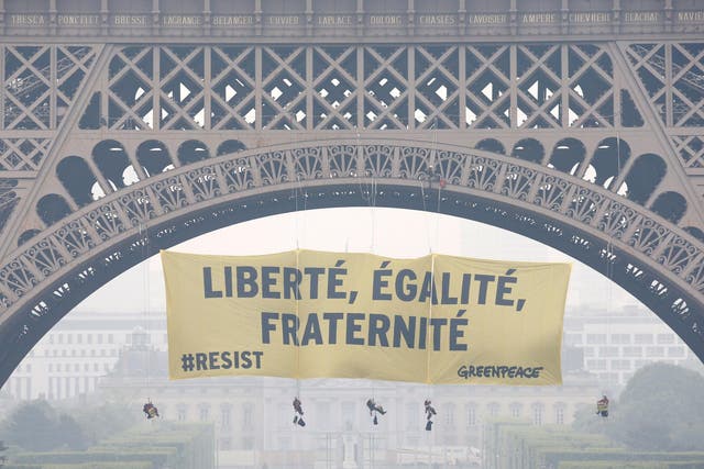 Activists from the environmentalist group Greenpeace unfurl a giant banner on the Eiffel Tower that reads 'Liberty, Equality, Fraternity' in a call on French citizens to vote against the National Front presidential candidate Marine Le Pen in Paris