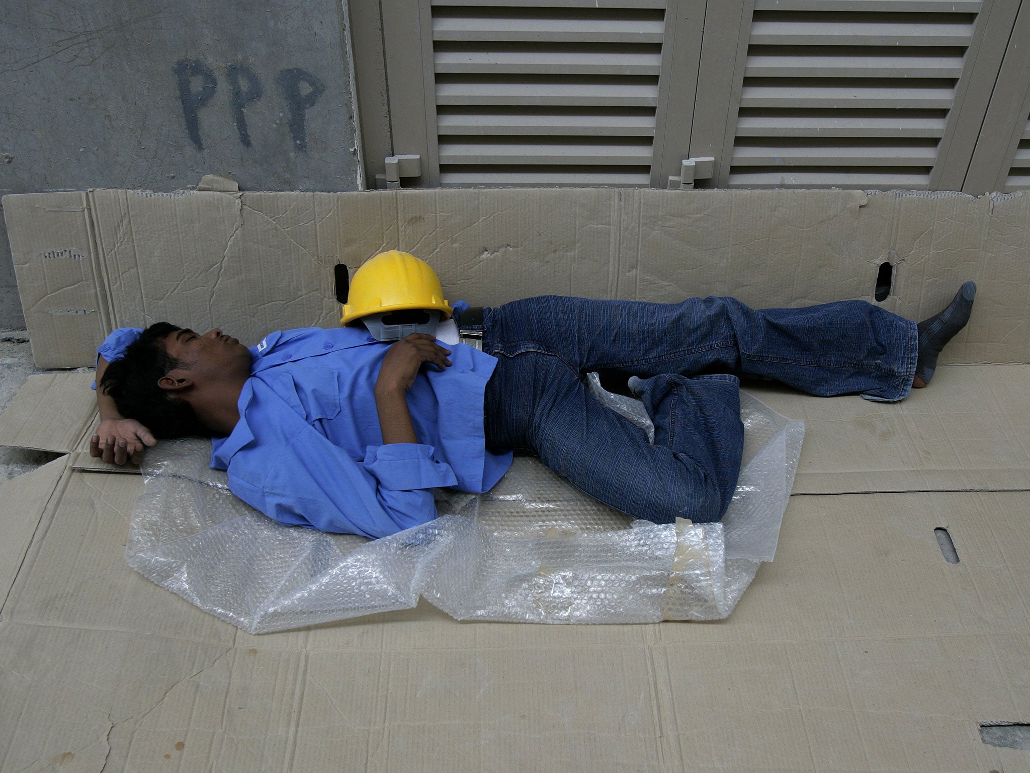 An exhausted migrant construction labourer working in Dubai (Getty)