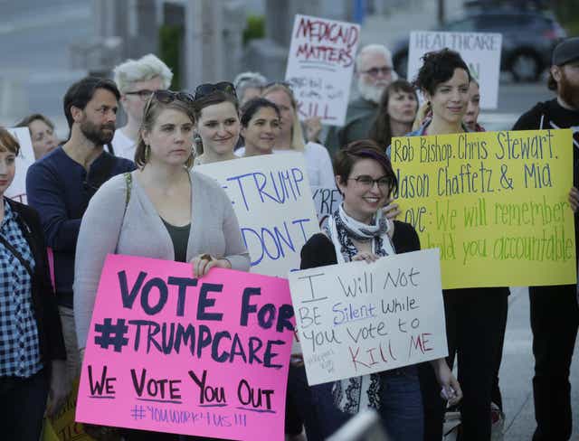 People look on during a healthcare rally in Salt Lake City.