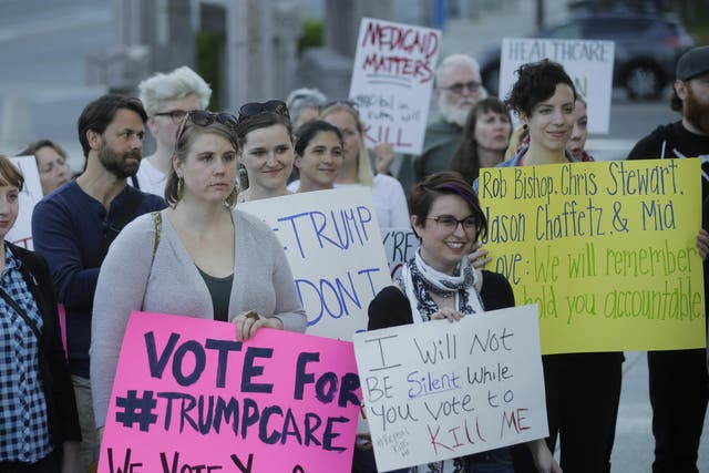 People look on during a healthcare rally in Salt Lake City.