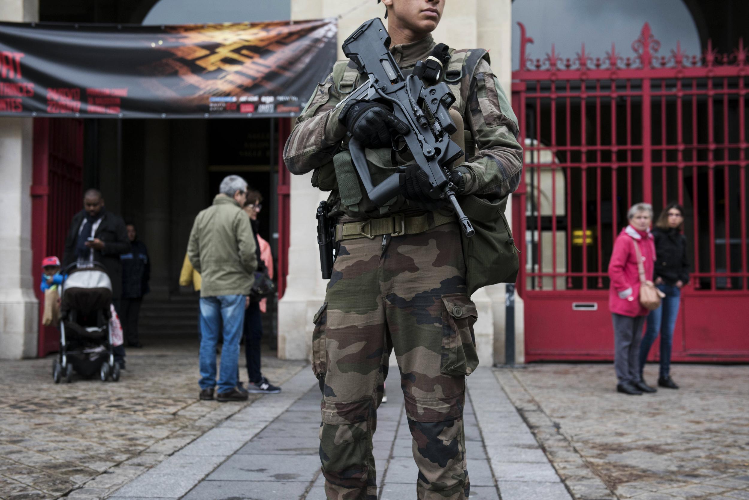An armed French soldier stands guard outside of a polling station in Paris