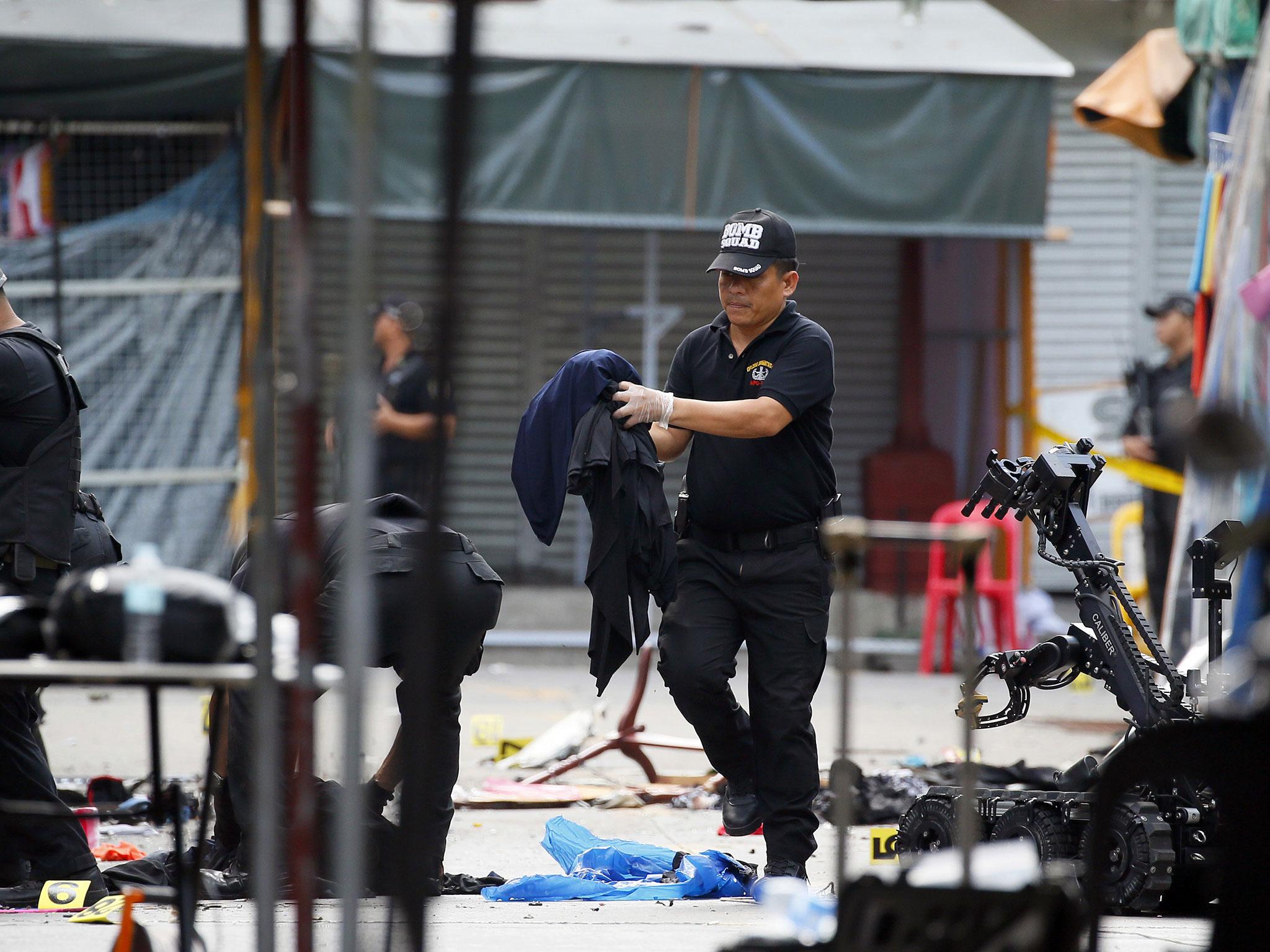 Bomb squad officers remove items from the scene of yesterday's bombing