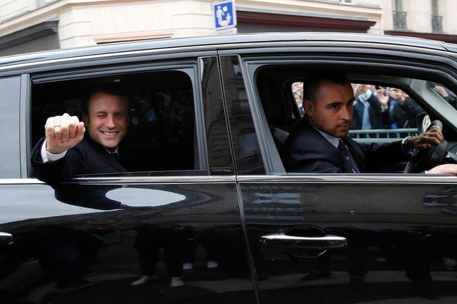 Emmanuel Macron waves from his car as he leaves his home