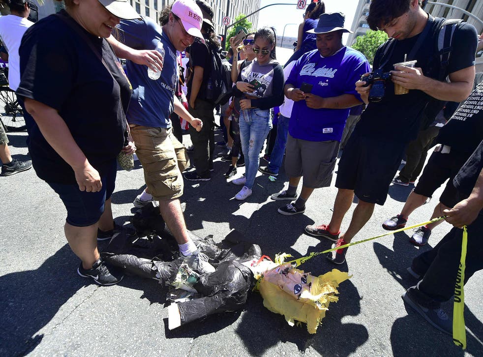 FILE IMAGE: A pinata of US President Donald Trump is stepped on and dragged during May Day protests