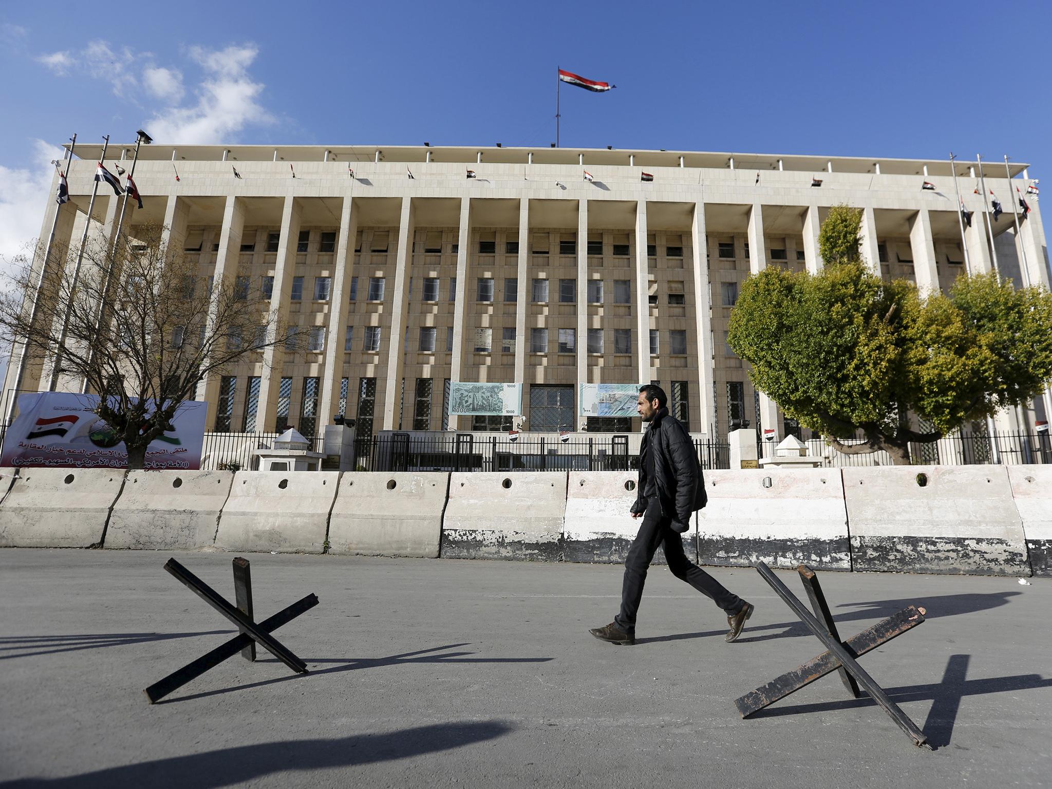 A man walks near the Central Bank of Syria in Damascus