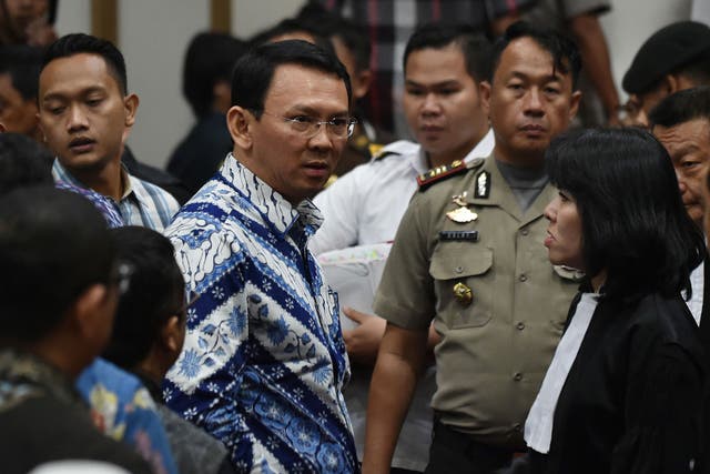 Jakarta's Christian governor Basuki Tjahaja Purnama (C), popularly known as Ahok, speaks to his lawyers after judges delivered their sentence during the verdict in his blasphemy trial