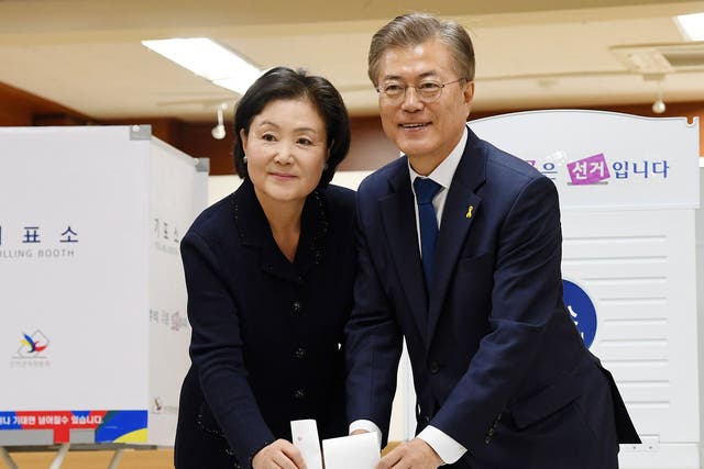 Presidential candidate Moon Jae-in (R) and his wife Kim Jeong-suk cast their ballots at a polling site in Seoul