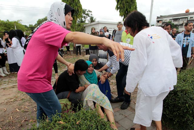 People carry an injured woman at the site of a bomb attack outside of a supermarket in the city of Pattani, Thailand, on 9 May