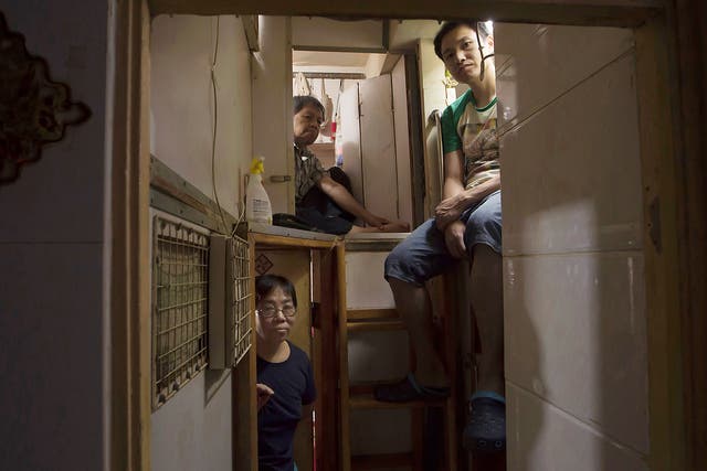 Hong Kong residents, who only gave their surname, Lam, top left, Wan, top right, and Kitty Au, pose at their 'coffin homes' in Hong Kong