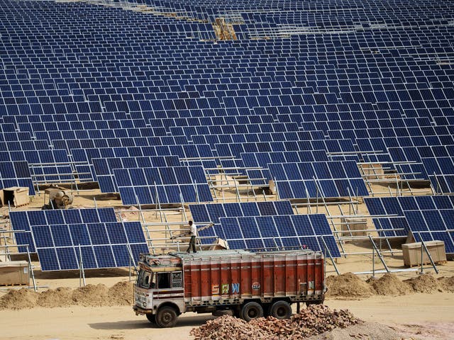 Indian engineer positions solar panels at the under construction Roha Dyechem solar plant at Bhadla in the western Indian state of Rajasthan