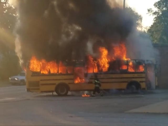 A firefighter battles flames after children were evacuated from a school bus in South Carolina