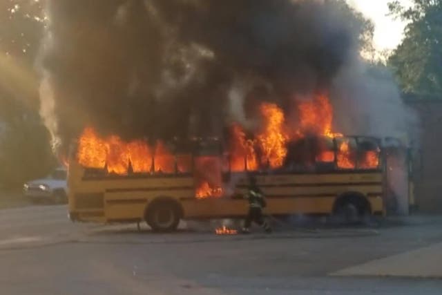 A firefighter battles flames after children were evacuated from a school bus in South Carolina