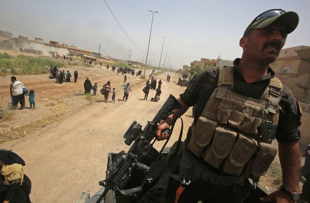 Members of Iraq's elite Counter-Terrorism Service (CTS) stand guard as displaced Iraqis from western Mosul's al-Islah al-Zaraye neighbourhood flee their homes on 11 May 2017