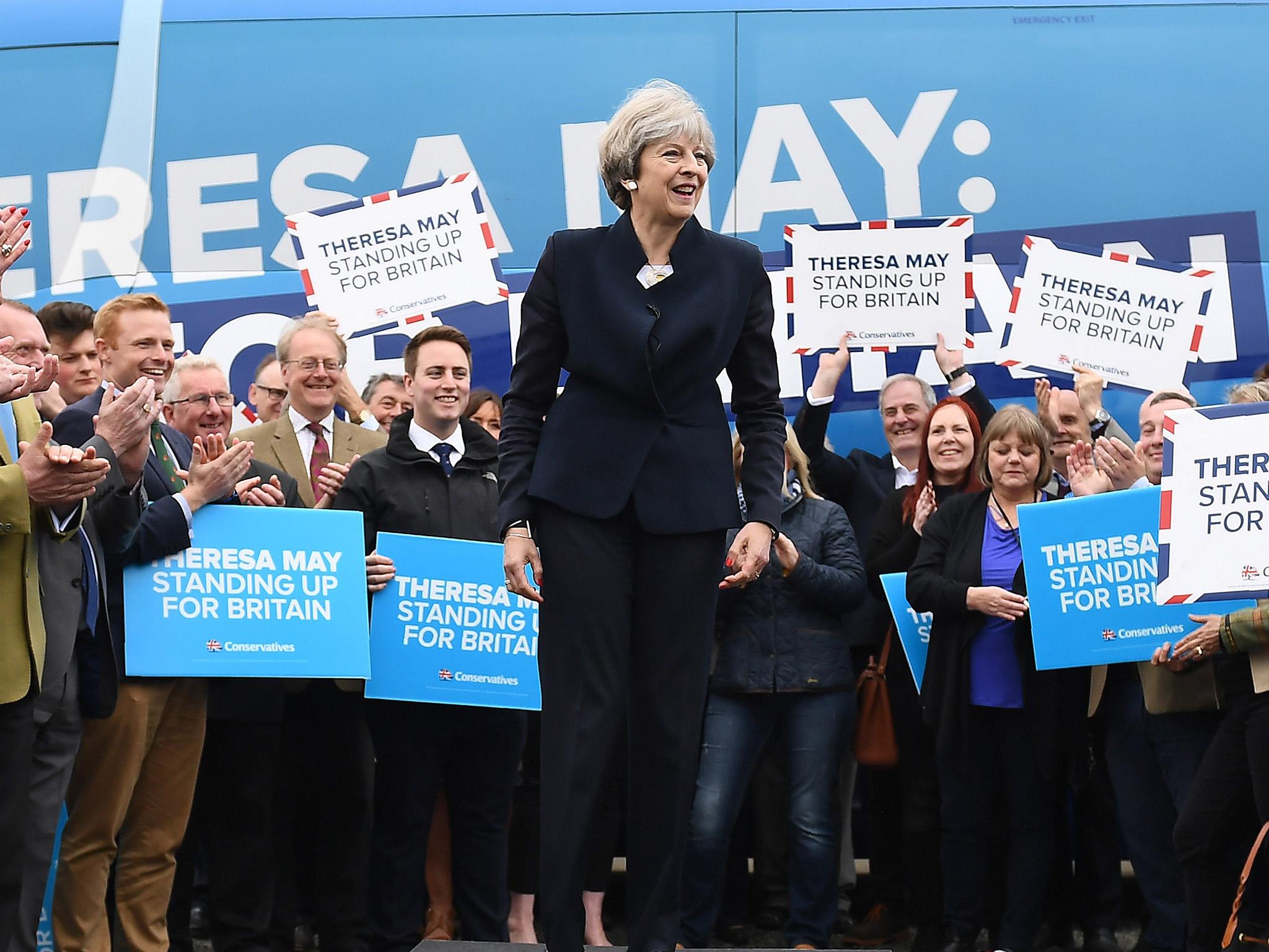 Theresa May speaks to party supporters in front of the Conservative Party's general election campaign battle bus