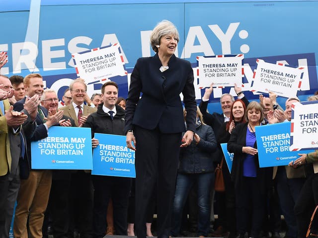 Theresa May speaks to party supporters in front of the Conservative Party's general election campaign battle bus 