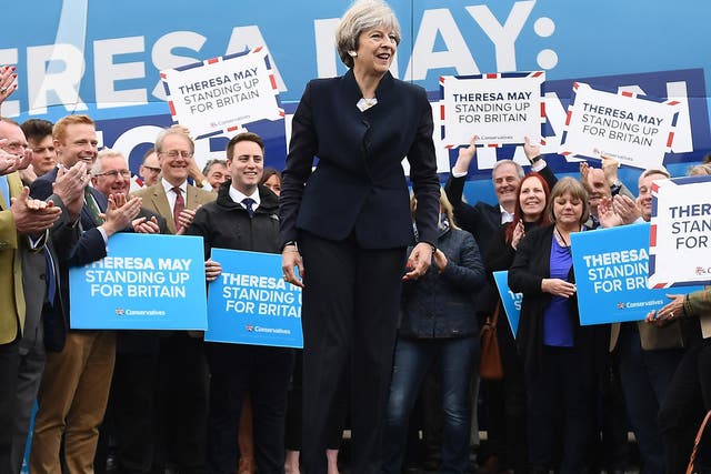 Theresa May speaks to party supporters in front of the Conservative Party's general election campaign battle bus 