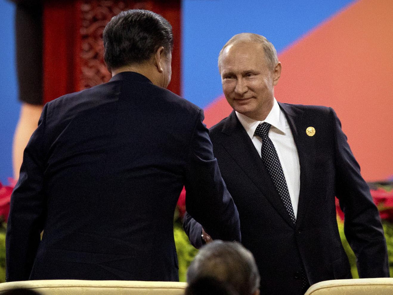 Russian President Vladimir Putin shakes hands with Chinese President Xi Jinping on Sunday during the Belt and Road Forum in Beijing