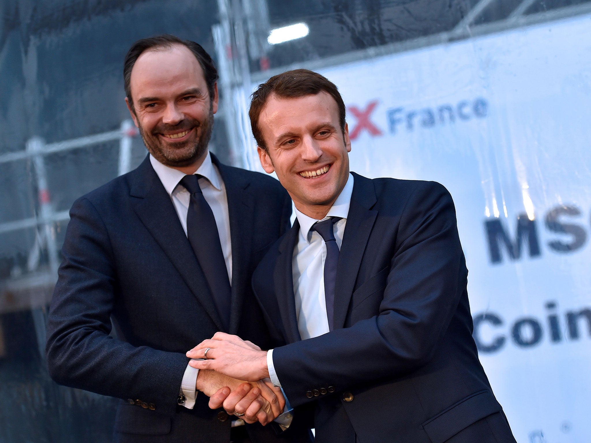 Photo from 1 February, 2016 shows French Economy Minister Emmanuel Macron (R) shaking hands with mayor of Le Havres Edouard Philippe