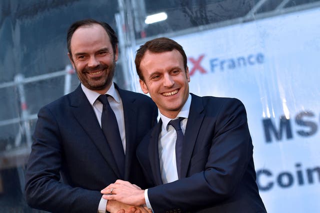 Photo from 1 February, 2016 shows French Economy Minister Emmanuel Macron (R) shaking hands with mayor of Le Havres Edouard Philippe