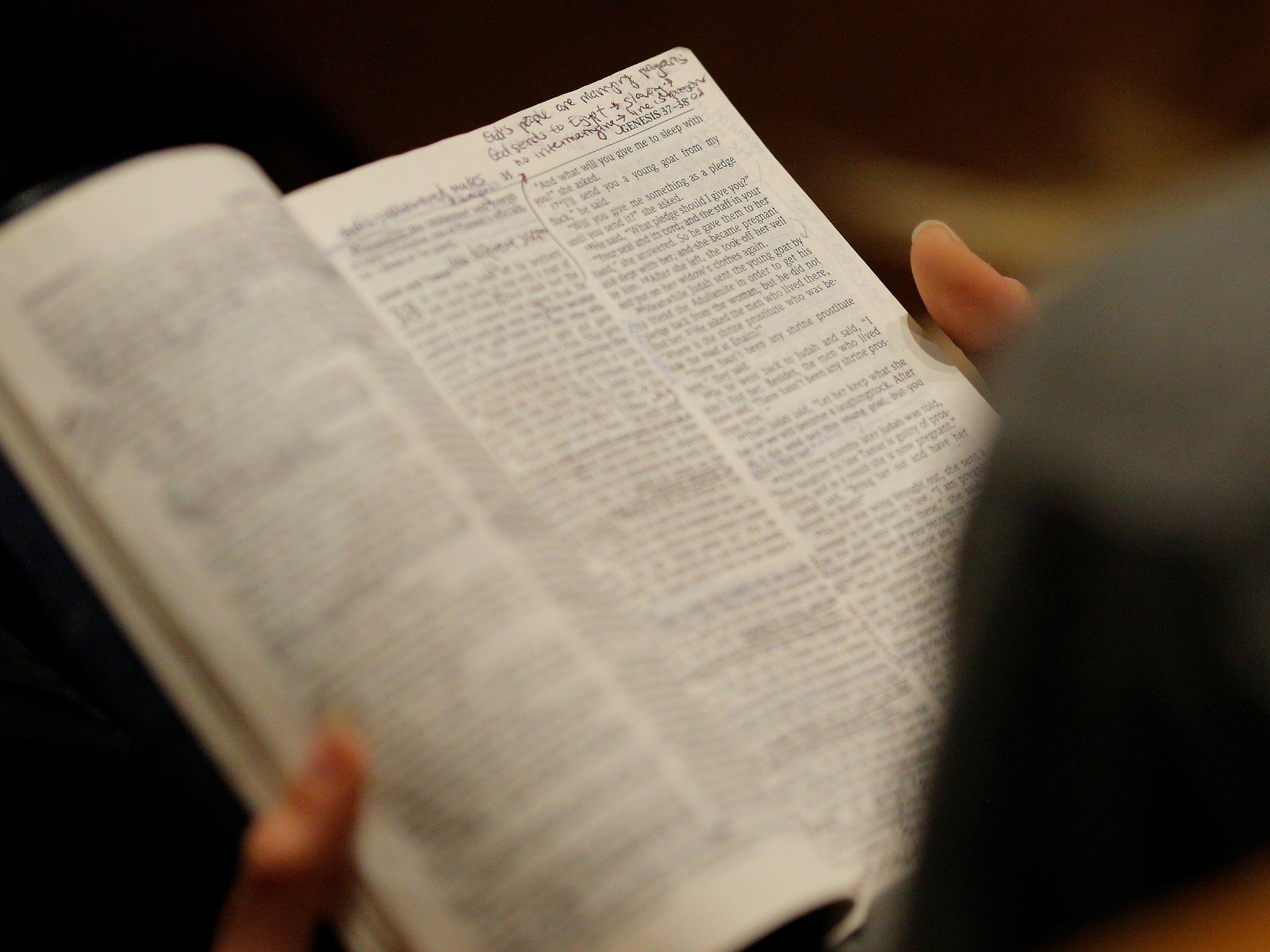 A woman reads a Bible in church