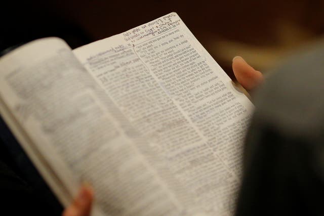 A woman reads a Bible in church