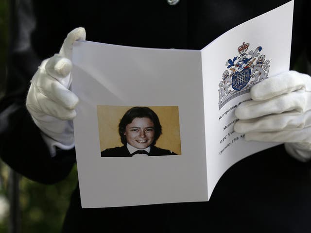 A police officer with an Order of Service for a memorial held in St James Square, London, to mark the thirtieth anniversary of the death of PC Yvonne Fletcher