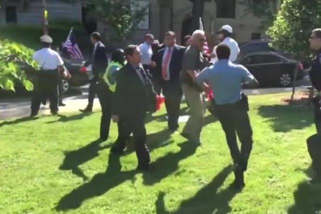 Several suited men suddenly run across the grass to attack pro-Kurdish protesters in shocking footage