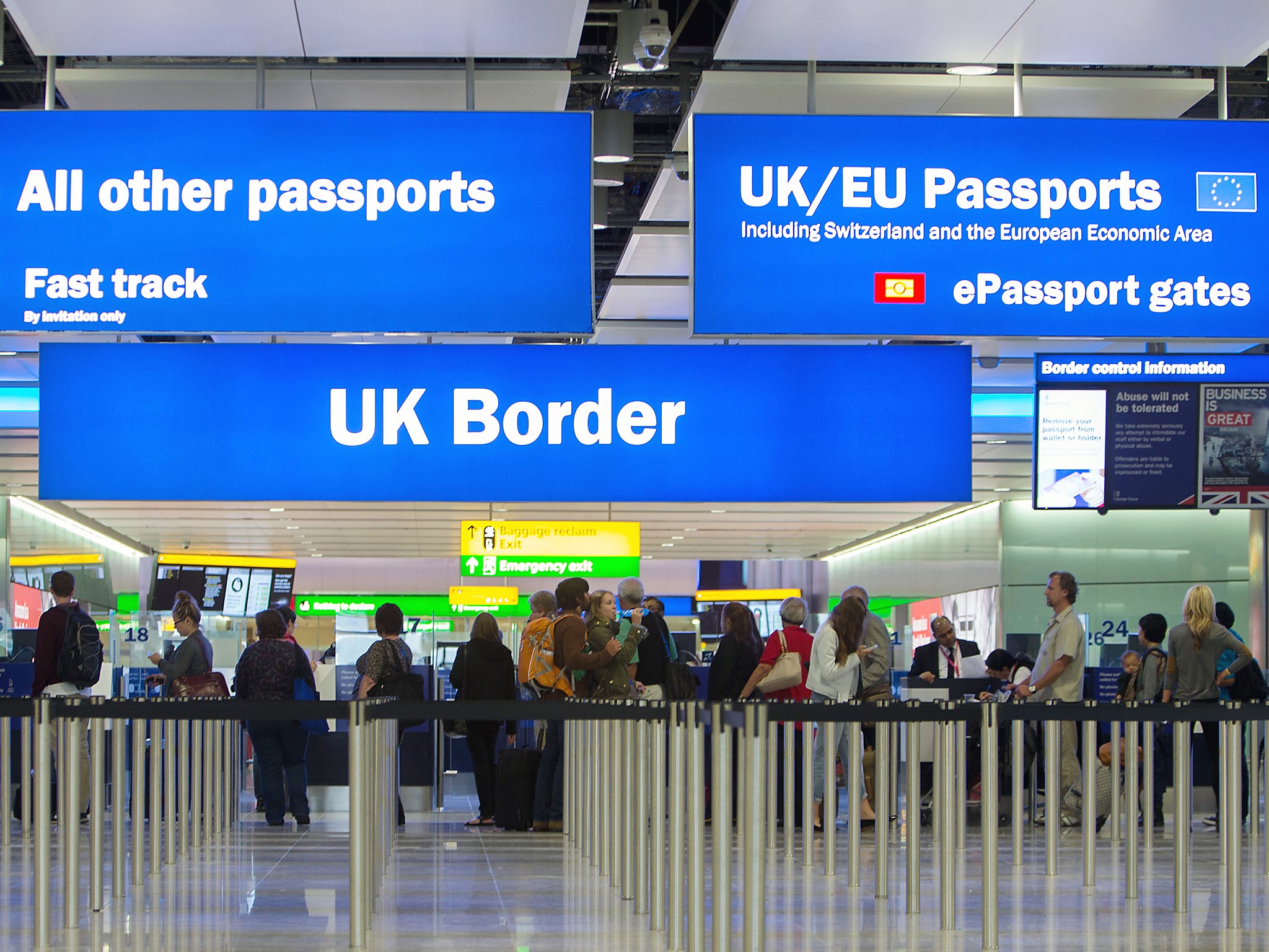 Passengers pass through border control at Heathrow Airport