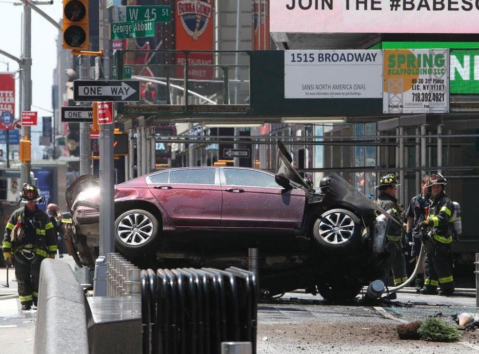 A red saloon car in Times Square, New York. Witnesses said it 'deliberately' crashed into pedestrians.