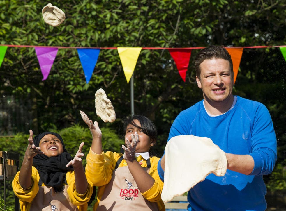 Jamie Oliver makes pizza dough with children from a primary school in east London