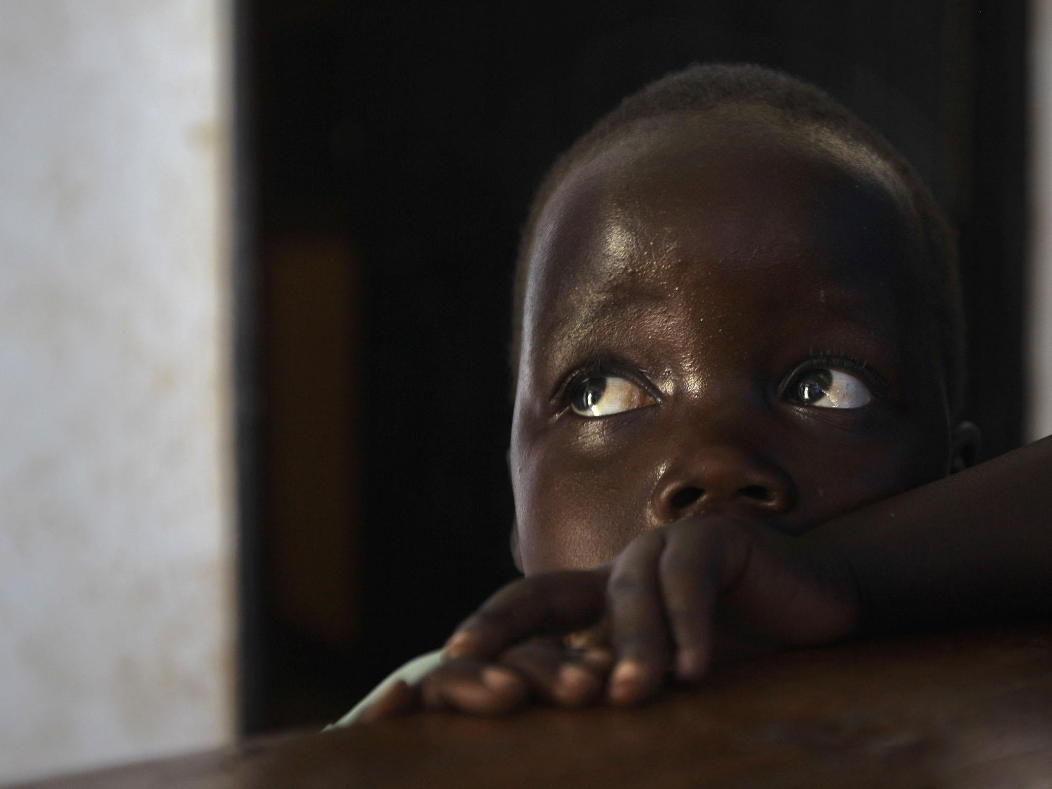 Betty, 3, looks up at her mother Adye Sunday, 25, unseen, who was abducted aged 13 by the LRA