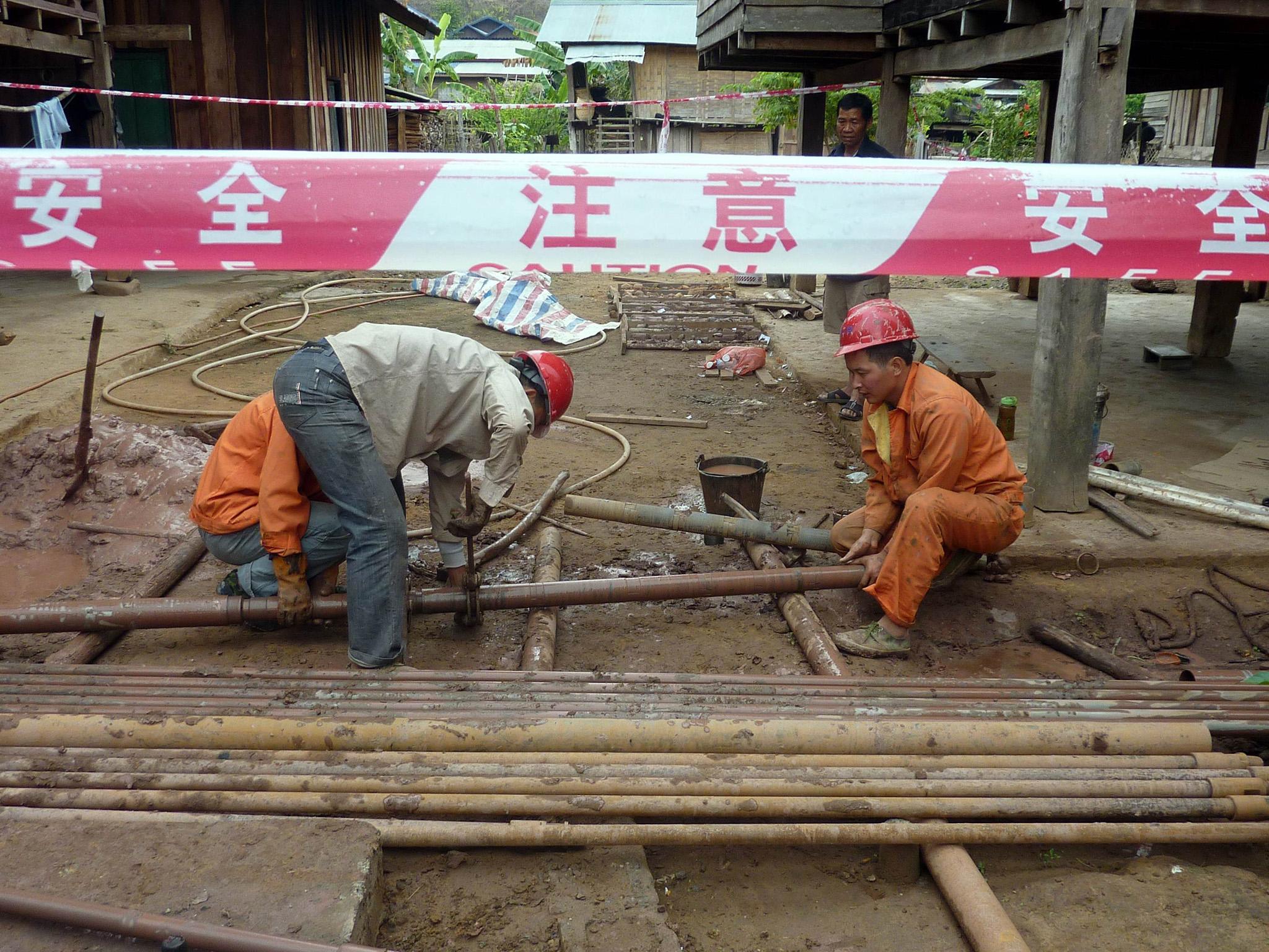 Chinese workers prepare for the building of a railway linking China to Laos at Bopiat village in the Northern province of Louang Namtha