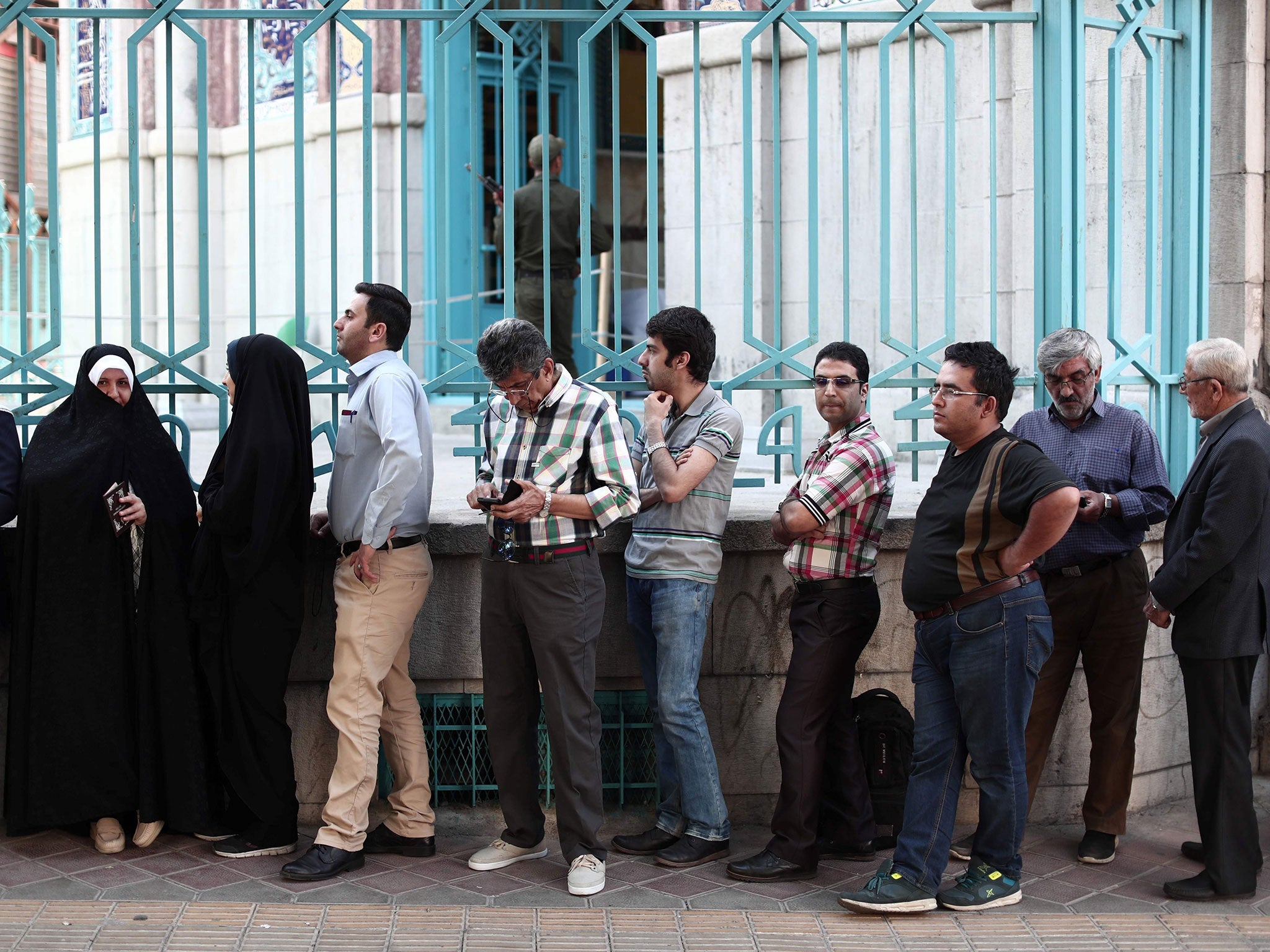 Iranians queue at a polling station to cast their ballots for the presidential elections in Tehran