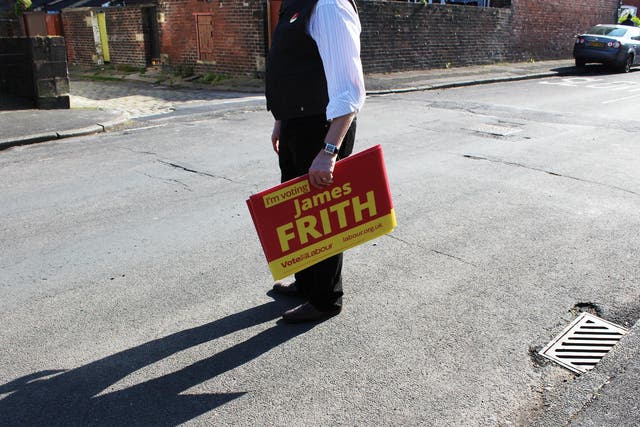 A campaigner holds a placard while door-knocking for Bury North Labour candidate James Frith