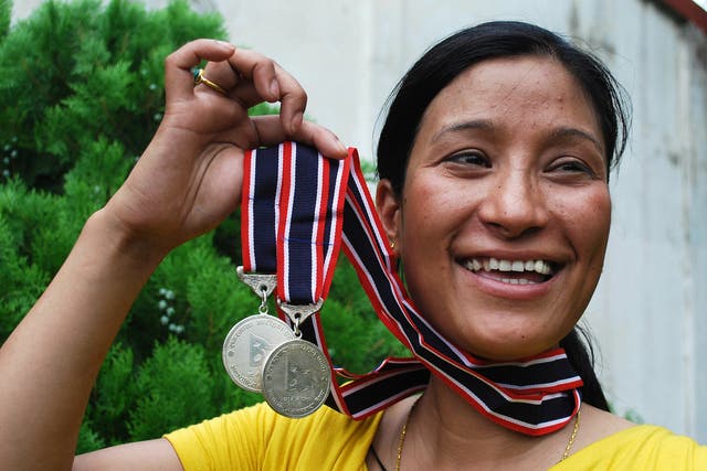 Anshu Jamsenpa holds the medals she received from the Nepalese government after climbing Mount Everest twice in 10 days in 2011.