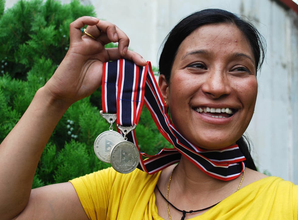 Anshu Jamsenpa holds the medals she received from the Nepalese government after climbing Mount Everest twice in 10 days in 2011.