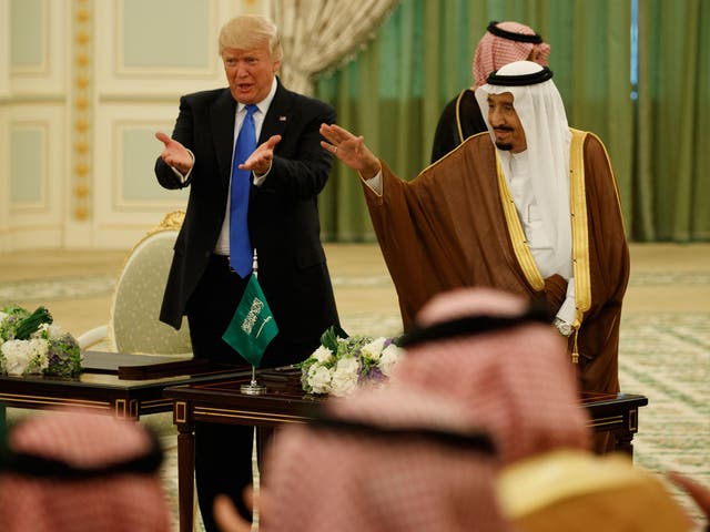 President Donald Trump and Saudi King Salman wave to the crowd during a signing ceremony at the Royal Court Palace/