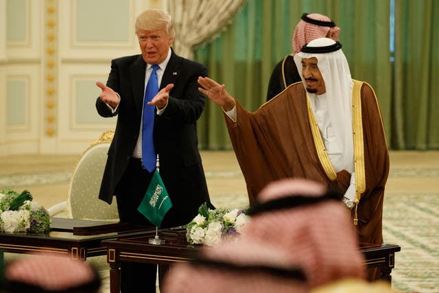 President Donald Trump and Saudi King Salman wave to the crowd during a signing ceremony at the Royal Court Palace/