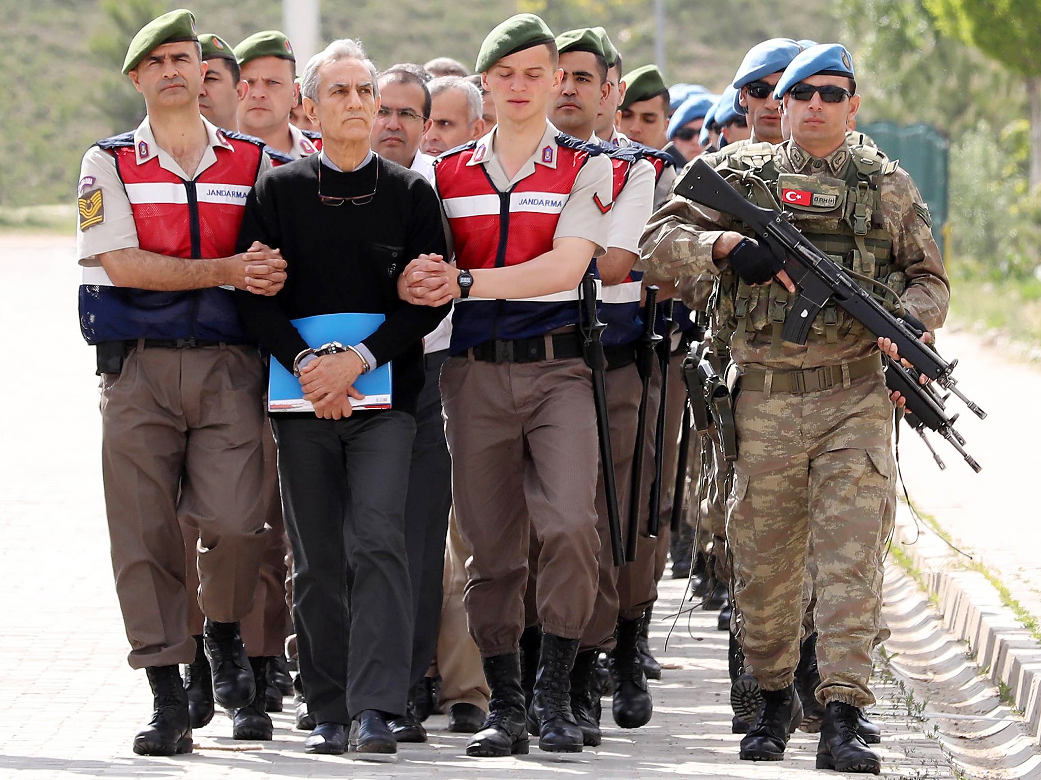 Turkish Gendarmerie escort defendant, Akin Ozturk and others involved in last July's attempted coup in Turkey as they leave the prison where they are being held, ahead of their trial in Ankara