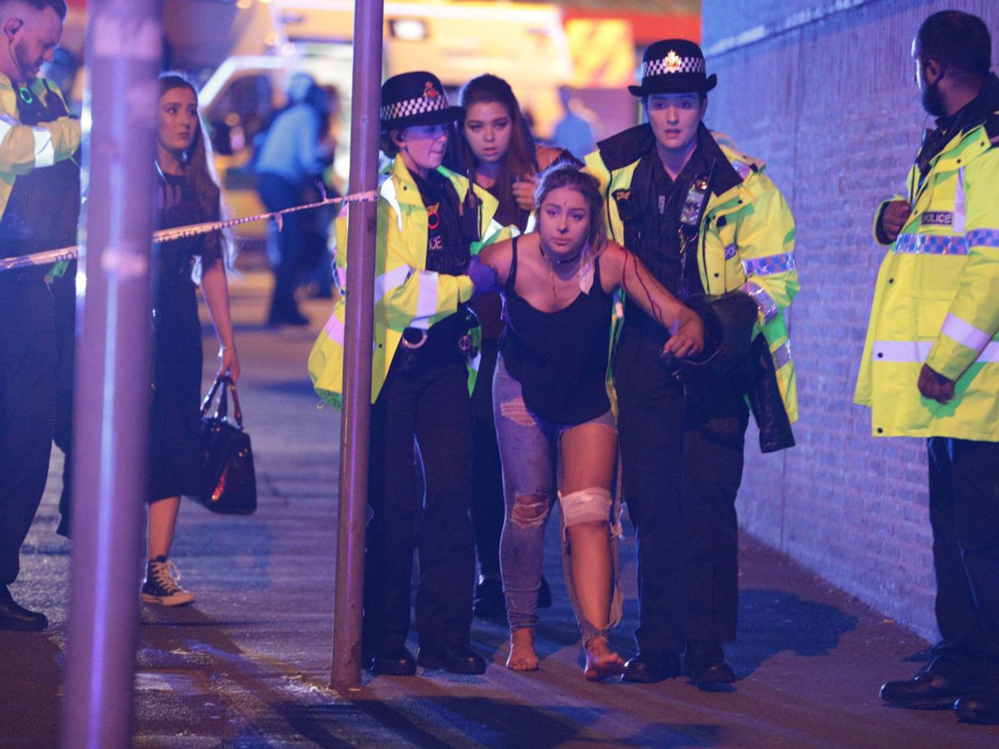 An injured woman is helped by emergency services in Manchester