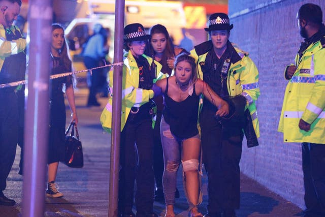 An injured woman is helped by emergency services in Manchester