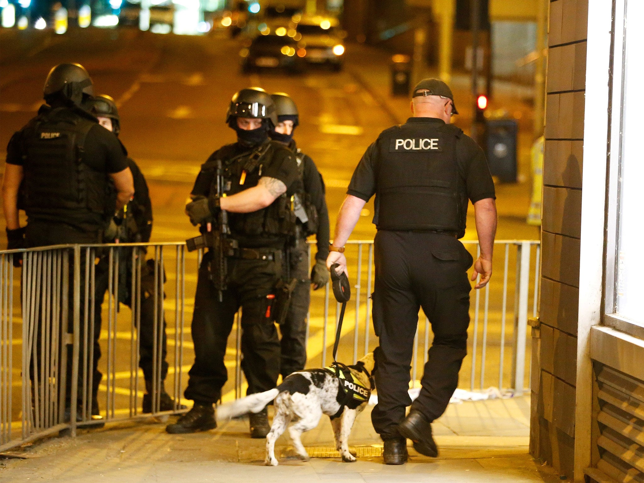 Armed police officers stand near the Manchester Arena